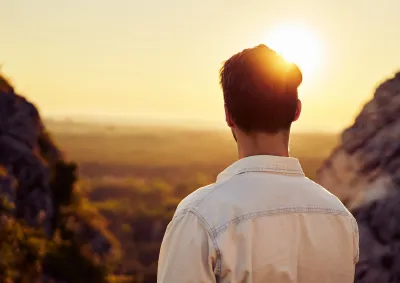 Man watching sunset hiking in mountains