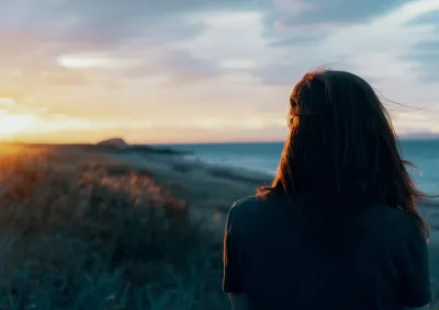 Person looking at ocean and sun.